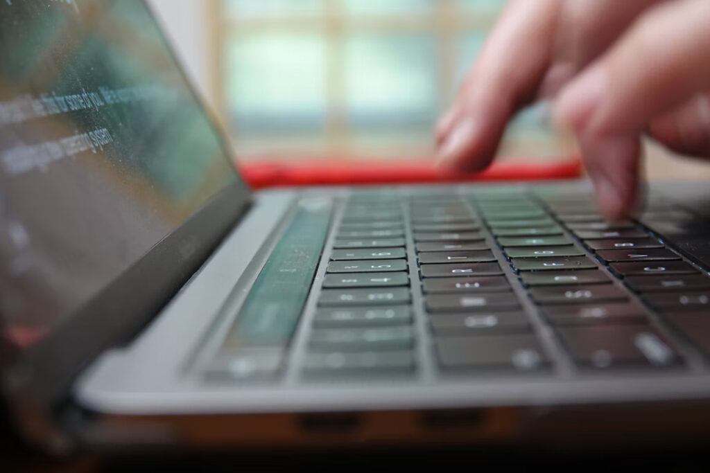 A close-up of a person typing on a laptop to request for an informational interview