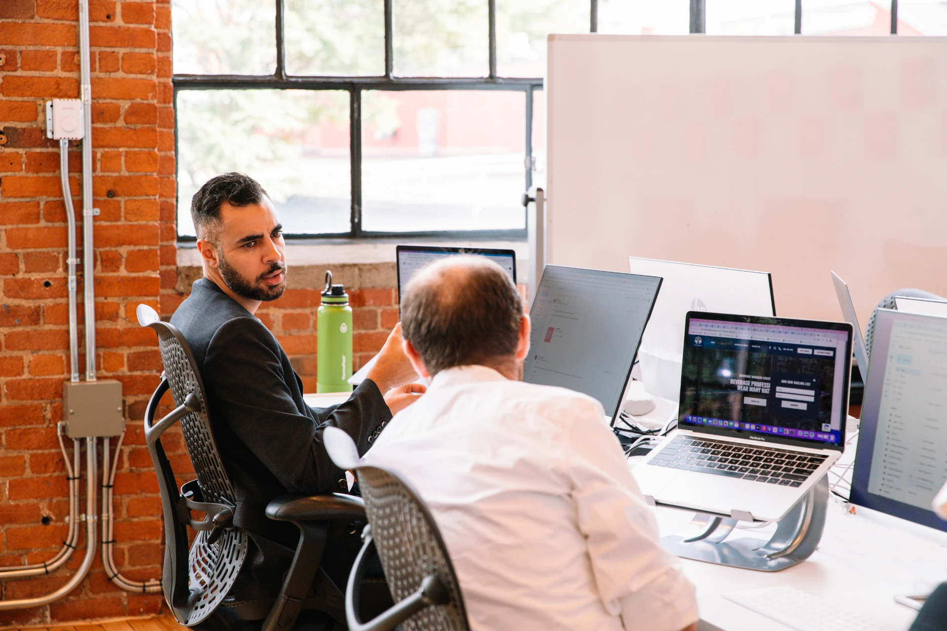 Two social media marketing professionals talking in an office 