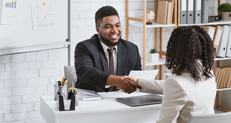 A recruiter shaking hands with an employee up for internal promotion