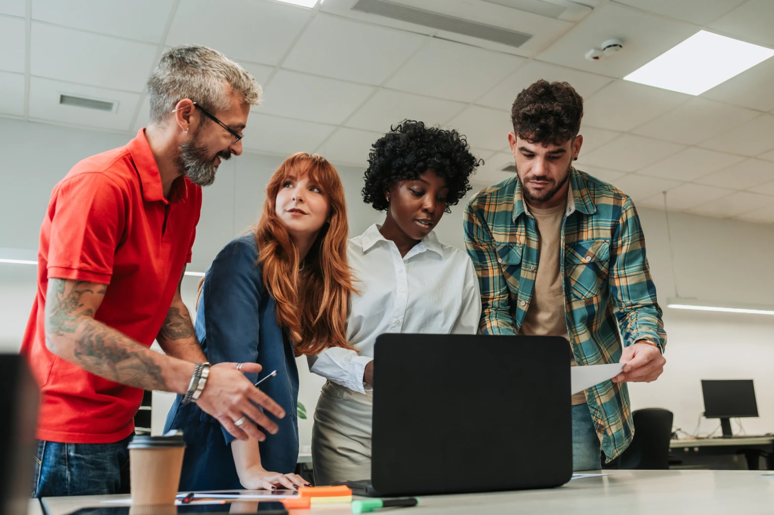 Four businesspeople looking at a laptop