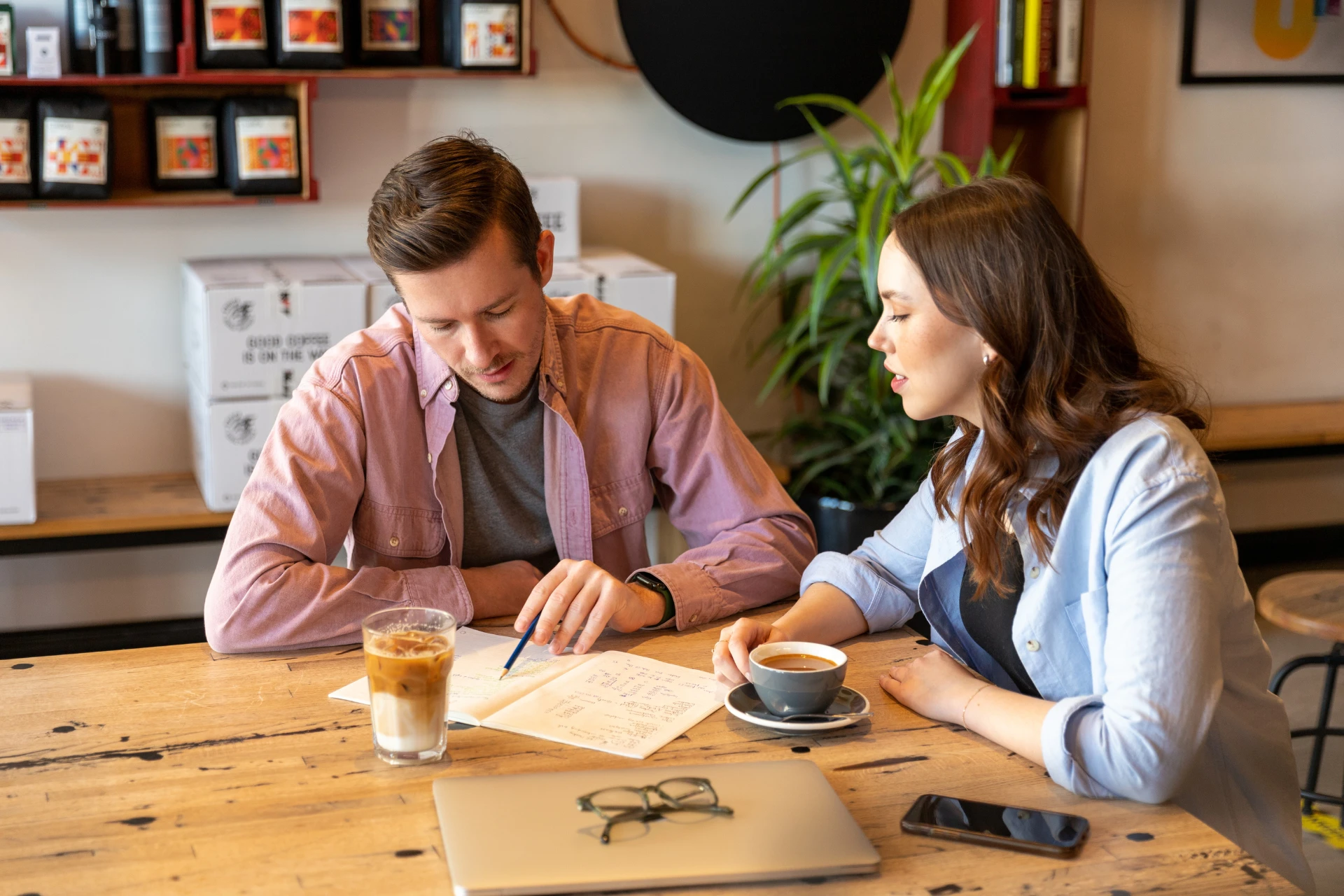 Two HR team members sitting at a table, discussing effective recruitment strategies over coffee