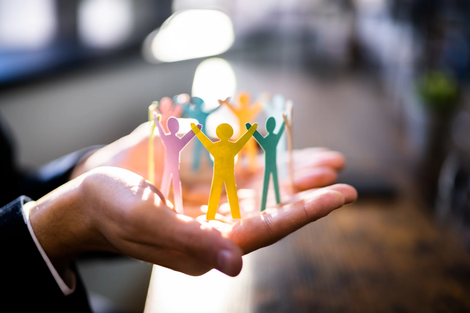 A cut-out of people raising their joined hands resting on top of a person’s palms