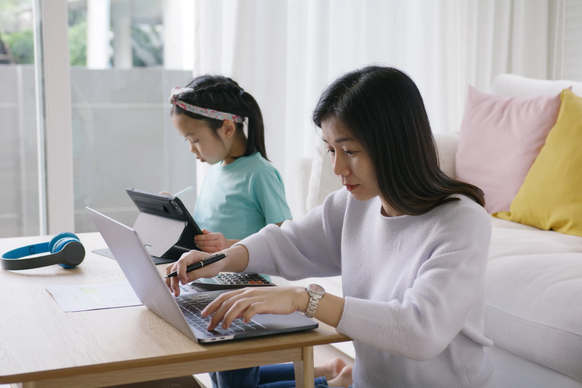 Mother working from home next to her child