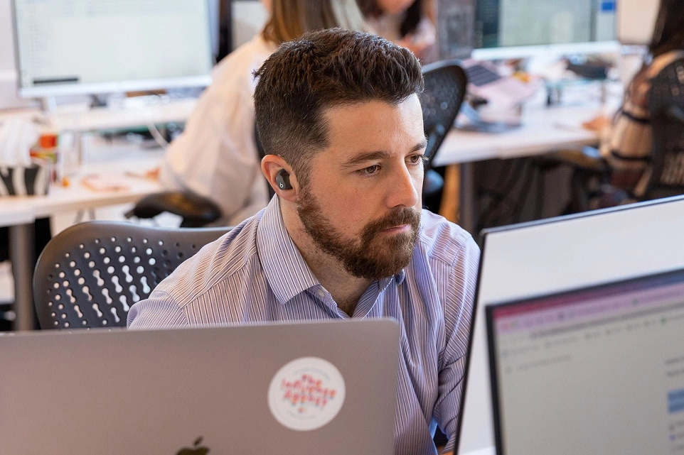 A bearded man staring at his computer