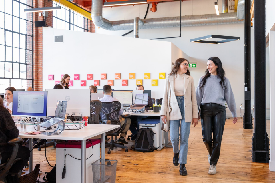 Two women walking side by side in the office