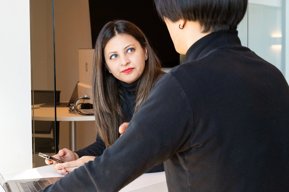 A woman on a laptop interviewing a person.