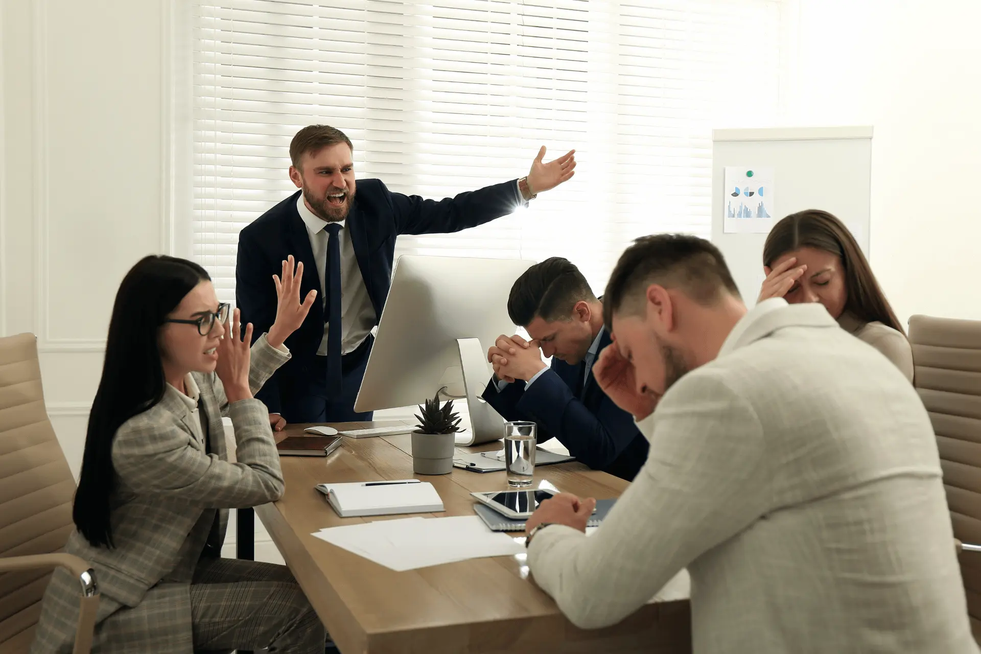 Boss screaming at employees in a meeting