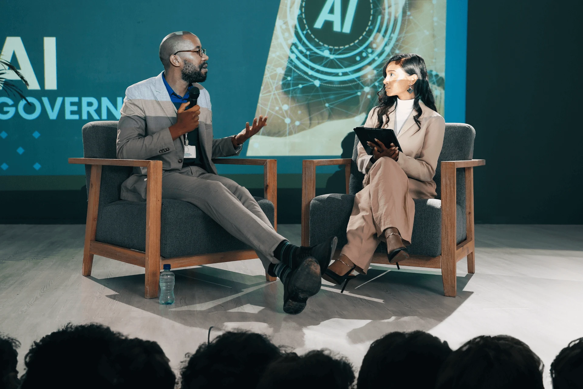 A pair of AI experts speaking in front of an audience at an event