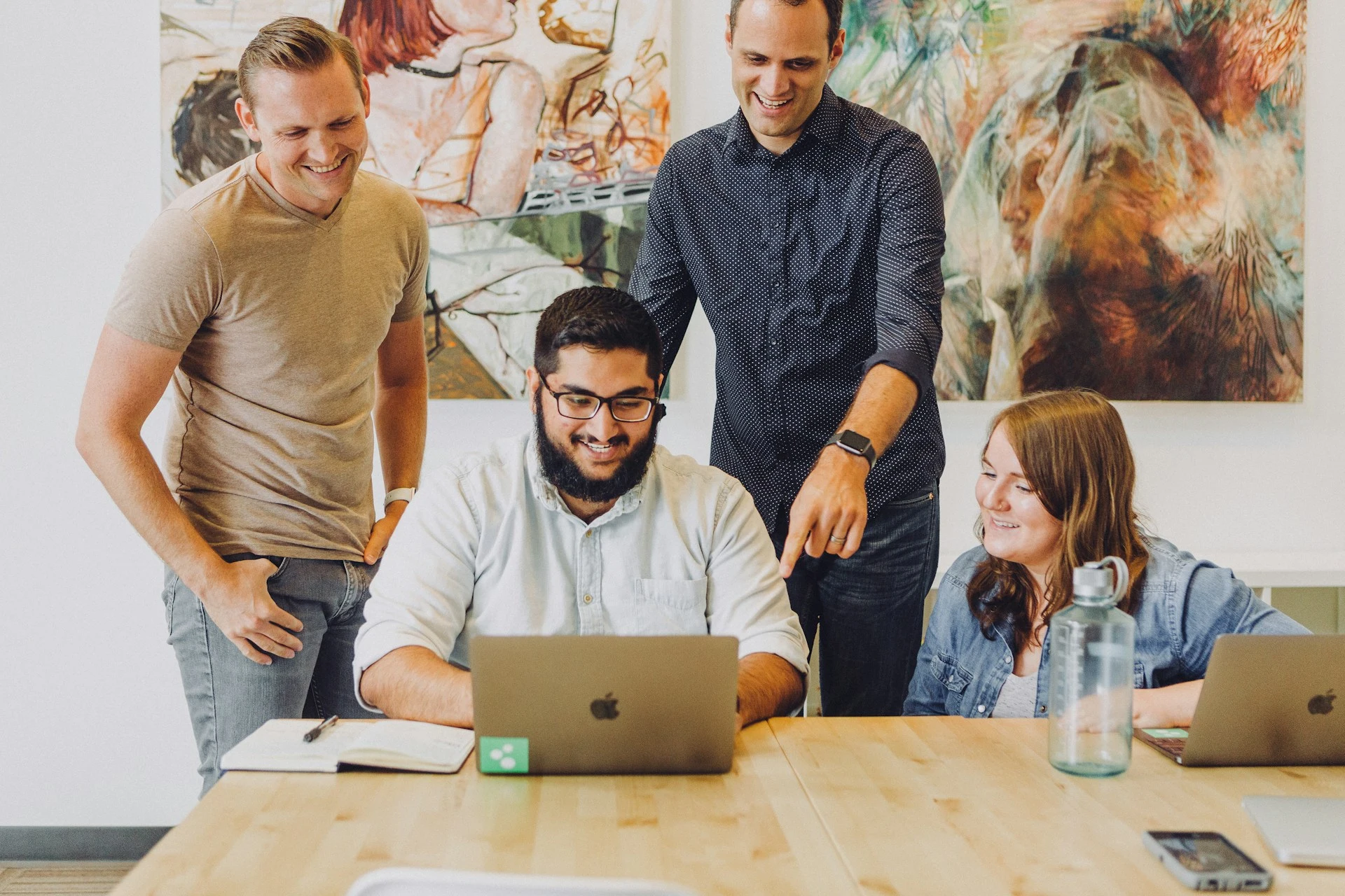 Group of coworkers looking at a laptop 
